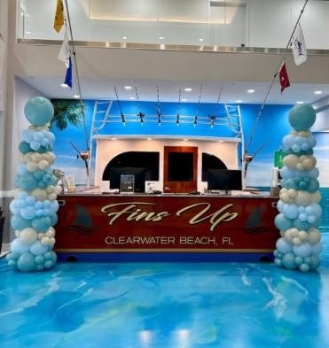 Blue and white balloon columns flanking the Fins Up Clearwater Beach reception desk